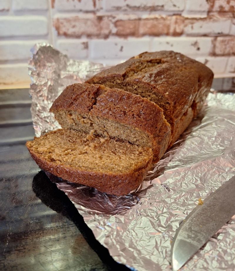 Homemade ginger loaf cake with slices cut from the front, showing its moist crumb and rich ginger colour.