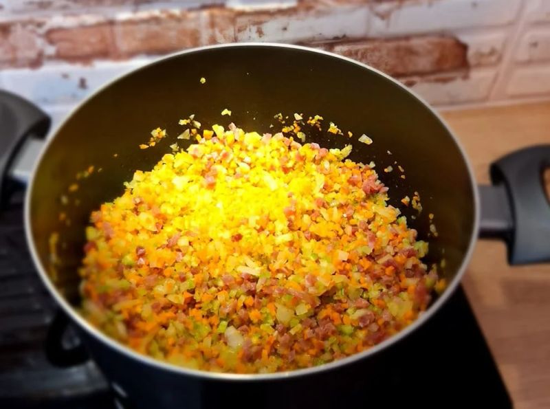 Pancetta, carrot, celery and onion cooking in a large pot