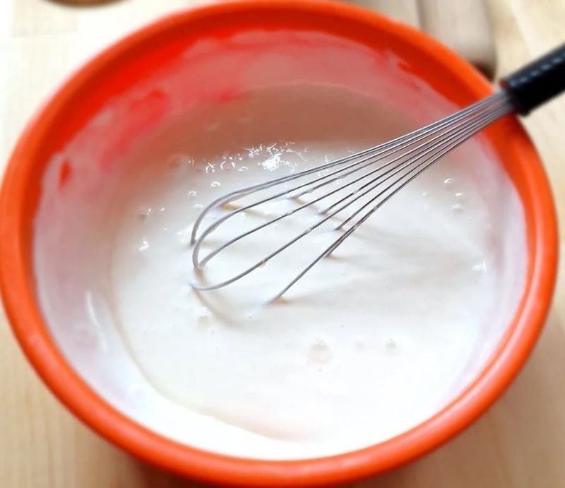 Cream cheese and condensed milk being whisked together for a no-bake cheesecake filling