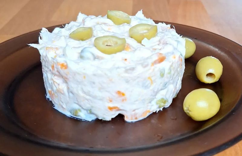 Ensaladilla rusa served with sliced and whole green olives