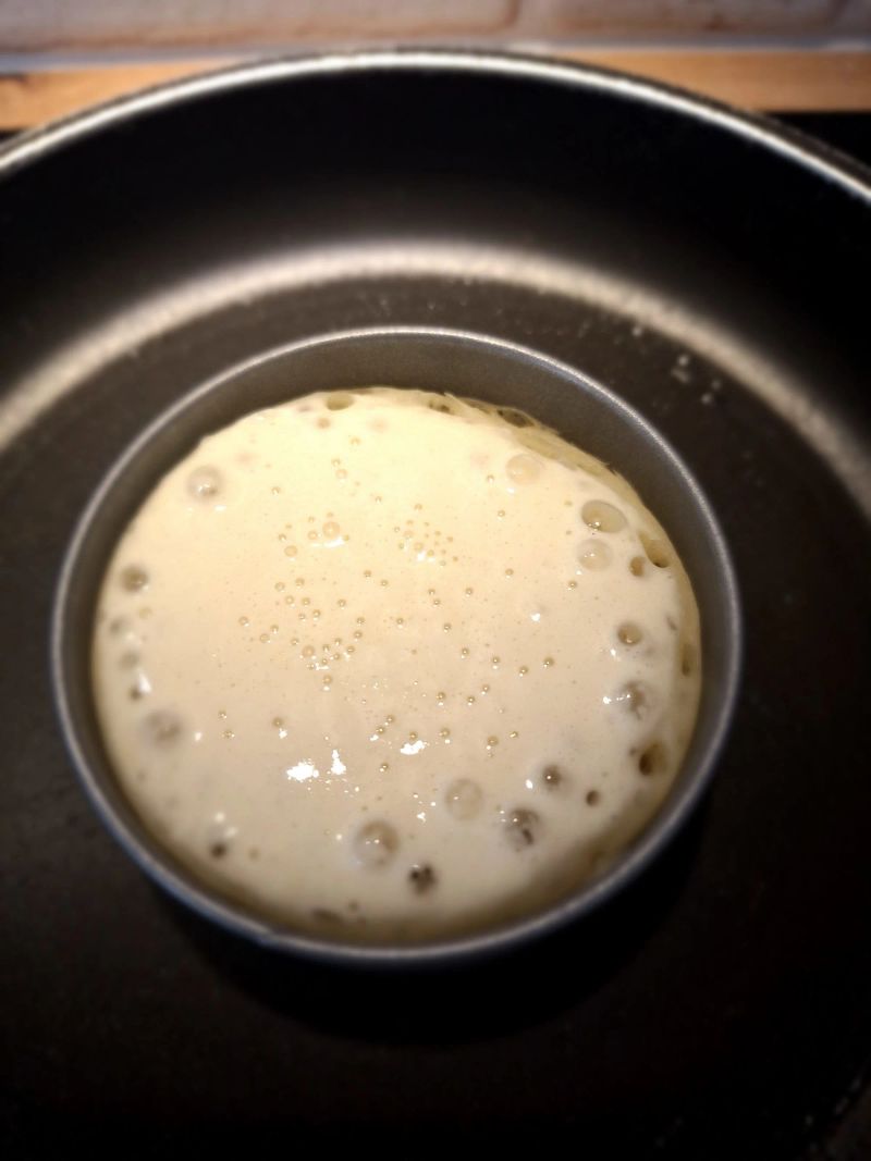 Close-up of bubbles forming across an English crumpet as it cooks